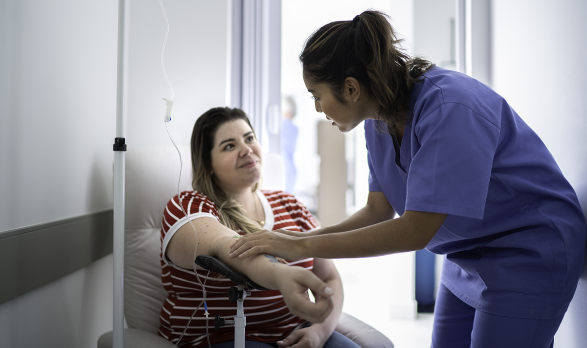 Patient interacting with a clinical staff member while receiving an infusion treatment